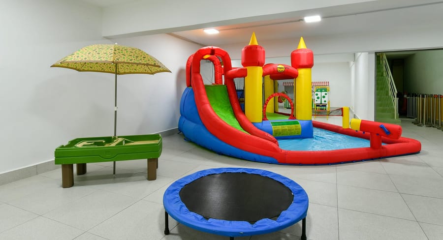 Water play room with a water slide and trampoline
